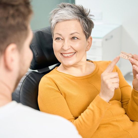 a patient holding a model of her teeth