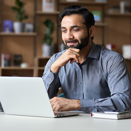 Man sitting at a table using his laptop