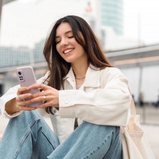 Lady smiles while viewing her smartphone