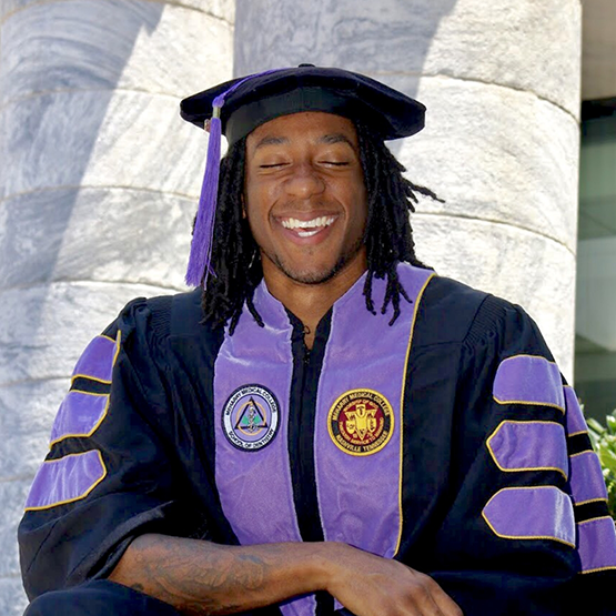Doctor Q wearing his dental school graduation cap and gown