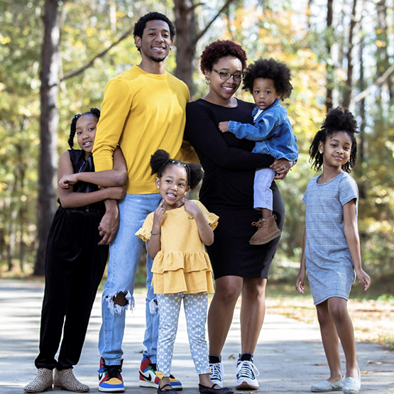 Doctor Q and his family smiling in a park