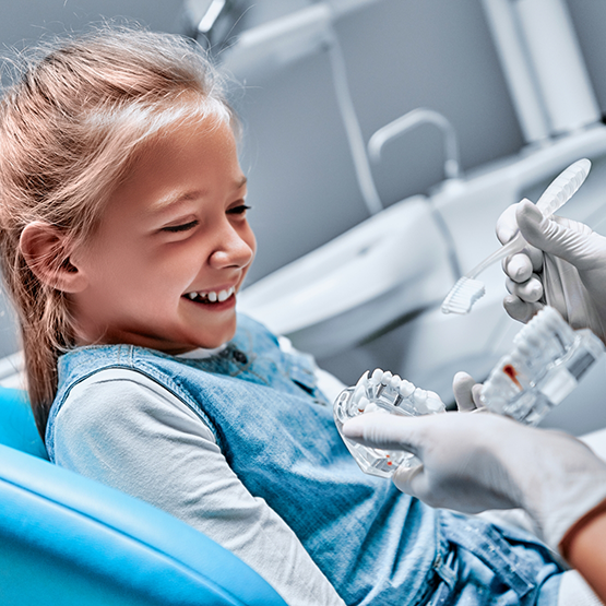 Young girl laughing in dental chair