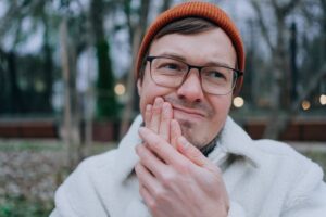 Young man holding mouth because of tooth sensitivity.
